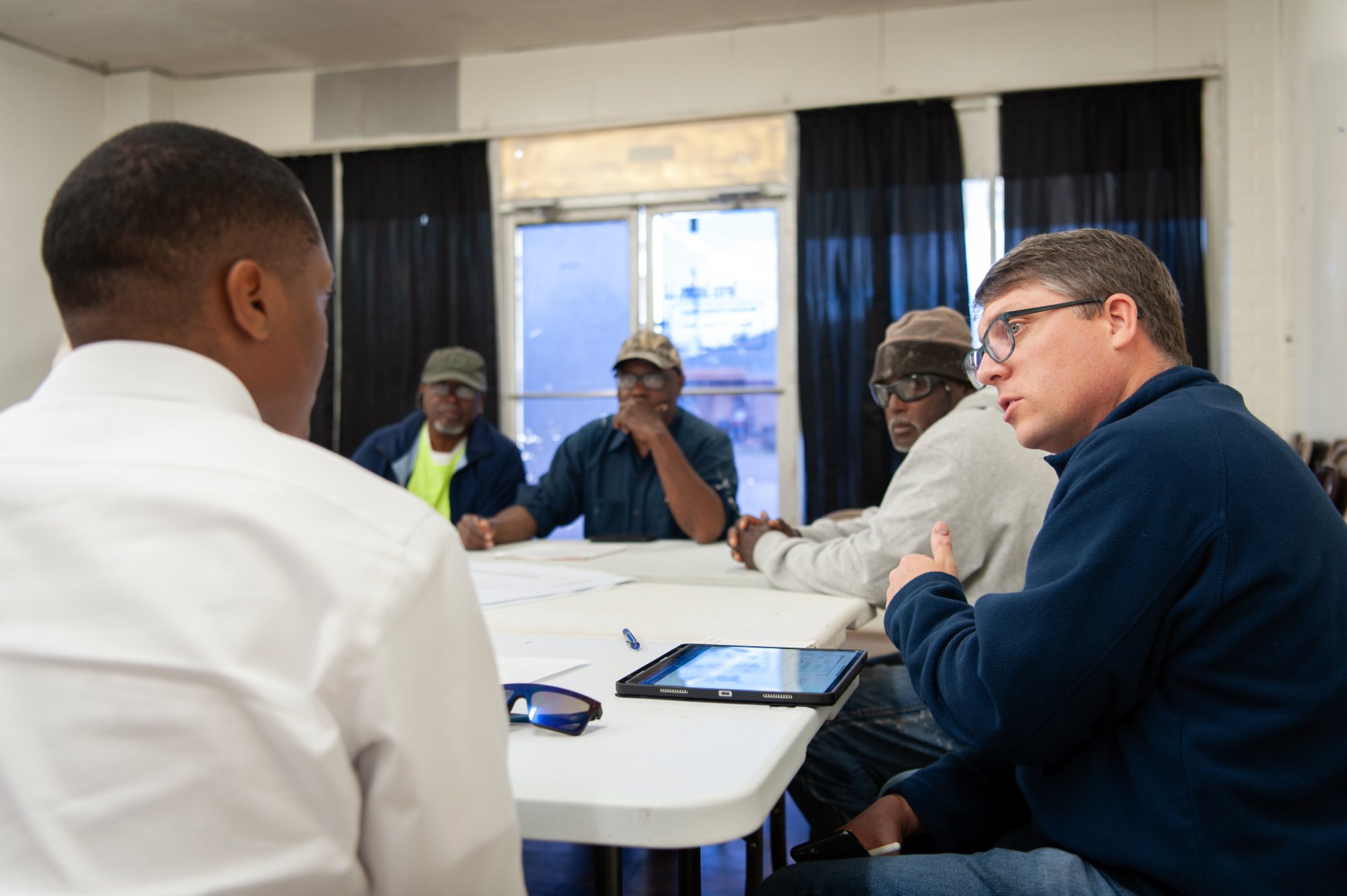 Residents and local leaders around a table at a community meeting
