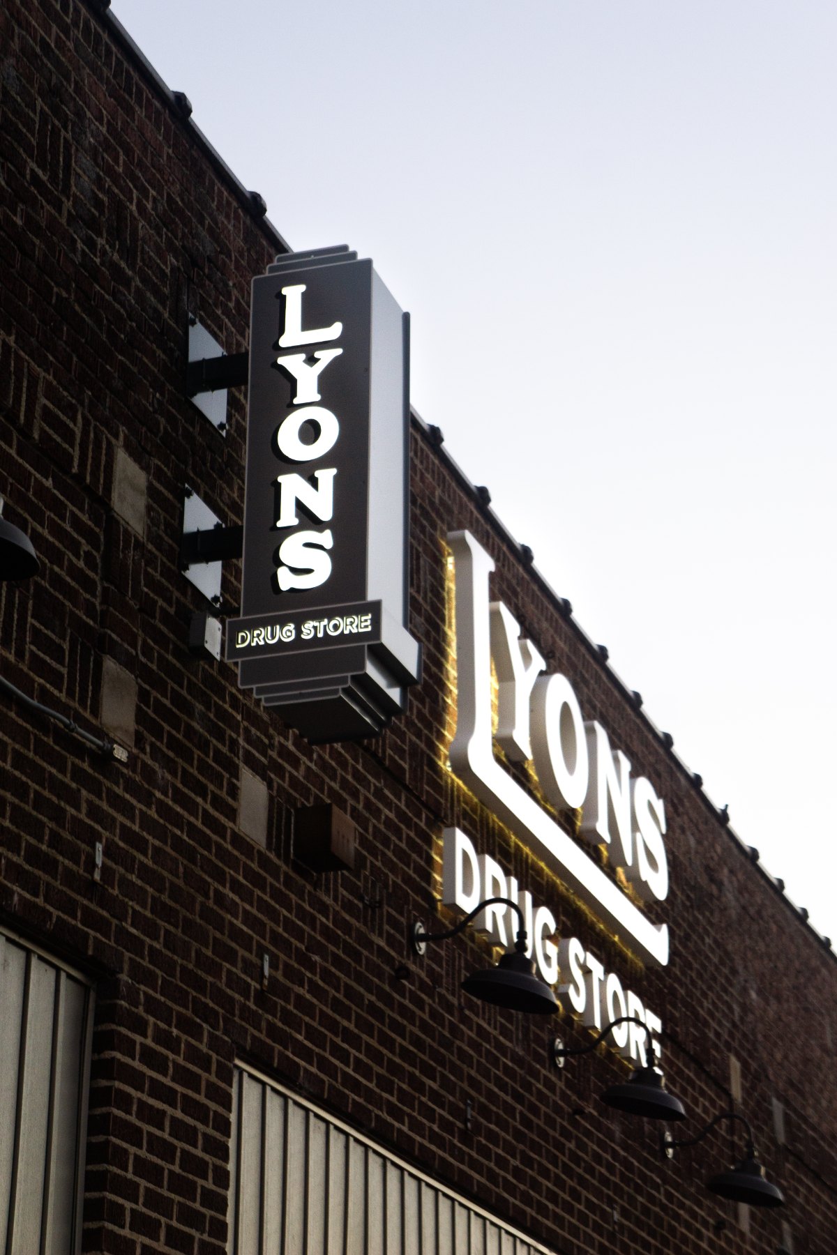 The revived Lyons Drug Store blade sign and wall letters on the brick facade
